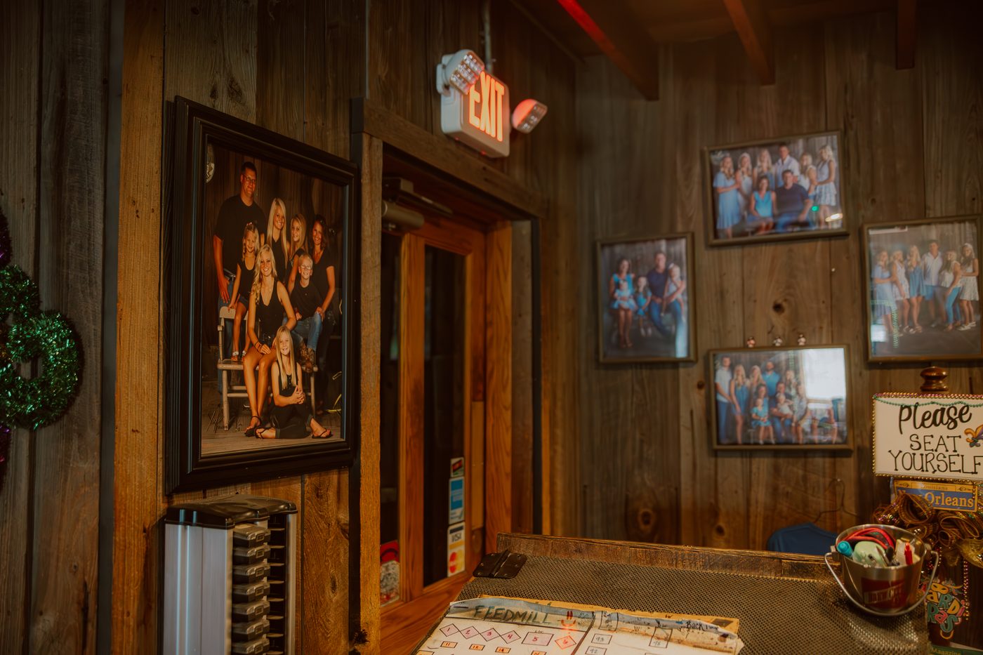 The host stand and family photos at the entrance
